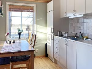 TallbackenHoliday home LIDKÖPING VIII的厨房配有白色橱柜、桌子和窗户。