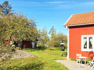 TallbackenHoliday home LIDKÖPING VIII的一间红色的房子,有白色的窗户和院子