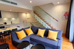 墨尔本Flagstaff Hill West Melbourne的客厅配有蓝色沙发及黄色枕头