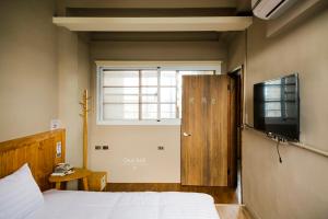 关山镇兴源行民宿 的一间卧室配有一张床、一台电视和一个窗口