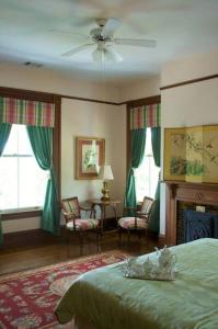 北奥古斯塔Lookaway Inn的一间卧室设有一张绿色的床和一个壁炉