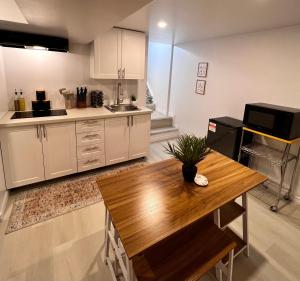 温莎The Boho Oasis的厨房配有白色橱柜和木桌