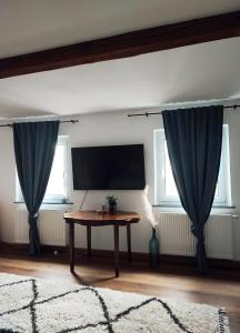 拜罗伊特Elias im Landhausstil的客厅配有桌子和蓝色窗帘