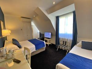 巴黎奥斯丁圣拉扎尔酒店的酒店客房配有两张床和一张书桌
