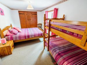 Calton松树小屋乡村别墅的一间卧室设有两张双层床和一扇窗户。