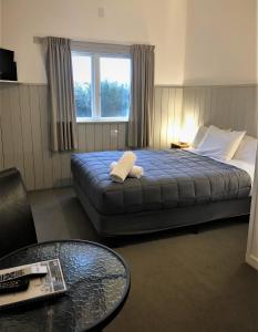 奥阿库尼国王奥阿库尼酒店的酒店客房设有一张带桌子和窗户的床。