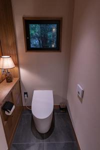 名户Treeful Treehouse Sustainable Resort的带窗户的客房内设有带卫生间的浴室