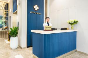 胡志明市Jovia Hotel的一位在前台打电话的人