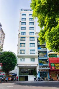 胡志明市Jovia Hotel的街道边高大的白色建筑