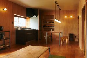 Ōtakuchi目の前が吉野川・雨天でも屋外体験ができる絶景の一軒家的一间带桌子的客厅和一间厨房
