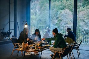 Ōtakuchi目の前が吉野川・雨天でも屋外体験ができる絶景の一軒家的一群坐在餐桌上吃食物的人