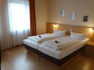 伊德施泰因Hotel Sonne - Haus 2的一间卧室配有一张带白色床单的大床