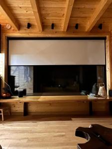科马尔尼克MoodySun Studio, remote tiny home的一个带木制天花板的房间内的大壁炉