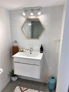 波塔灵顿The Cosy Bungalow的浴室设有白色水槽和镜子