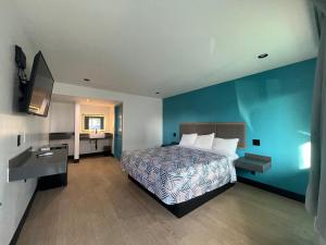 英格尔伍德Palm Inn Los Angeles NEW的一间卧室设有一张床和蓝色的墙壁