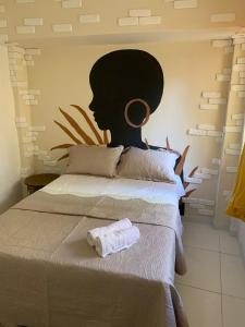 萨尔瓦多Aconchego de Itapuã的一张床上有毛巾,墙上有绘画