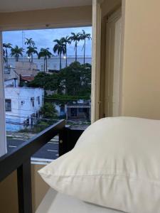 圣路易斯Hostel dos Poetas的一间卧室设有床铺和种有棕榈树的窗户。