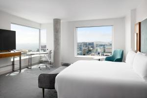 旧金山LUMA Hotel San Francisco - #1 Hottest New Hotel in the US 2023的酒店客房设有一张床、一张书桌和窗户。