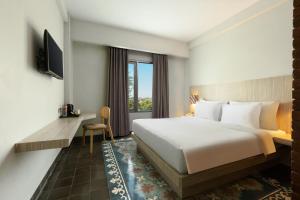 日惹日惹布尔扎酒店的酒店客房设有床和窗户。