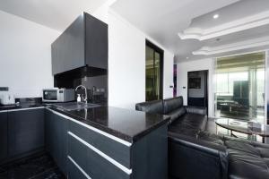 芭东海滩PATONG TOWER FAMILY APARTMENT by PTA的一个带黑色台面的厨房和一间客厅