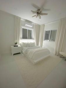 马尔斯港Moss Manor的白色卧室配有床和吊扇