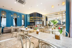 胡志明市Jovia Hotel的餐厅拥有蓝色的墙壁和桌椅
