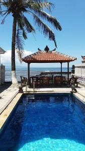 甘地达萨Catra homestay beach apartments的一个带凉亭和桌椅的游泳池