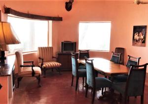 拉瓦尔品第Morgah Resort - Guest Rooms的一间带桌椅和电视的用餐室
