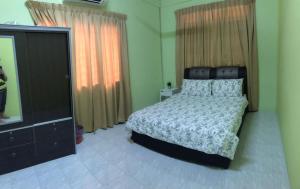哥打巴鲁Ruhani Homestay 2 Kota Bharu Cheap and Comfortable的一间卧室配有一张床和一台平面电视