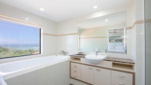 扬巴扬巴金沙度假公寓的带浴缸、水槽和窗户的浴室