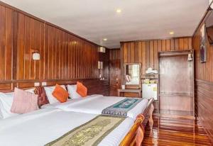 Ban Mai Ta SaengRiverside Chiangkhan的一间卧室配有一张带木墙的大床