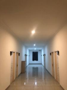 井里汶Damai Guest House Cirebon的大楼里空着门和舞台的走廊