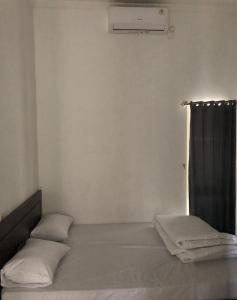 井里汶Damai Guest House Cirebon的一间卧室配有一张带黑色窗帘的床