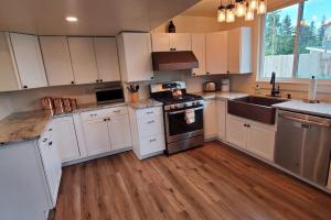 安克雷奇Luxury DT Cottage - Free Parking - Self Check-In的厨房配有白色橱柜和炉灶烤箱。