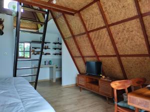 AngsriMagical Breeze Cabin的一间卧室配有一张床和一张书桌及电视