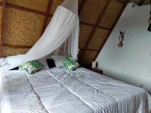 AngsriMagical Breeze Cabin的一间卧室配有一张带蚊帐的床
