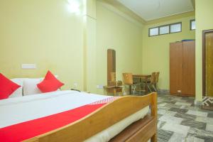 TādongCapital O Parasol Inn的一间卧室配有一张带红色枕头的床和一张桌子