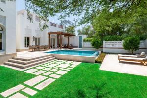 多哈Al Messila, A Luxury Collection Resort & Spa, Doha的后院设有游泳池和绿草