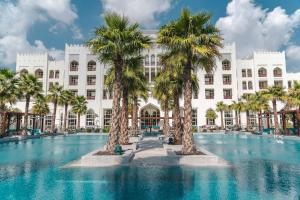 多哈Al Messila, A Luxury Collection Resort & Spa, Doha的前面有棕榈树的酒店