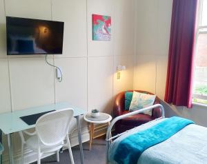 但尼丁Extended Stay City Hostel的客房设有1张床、1张桌子和1台电视。