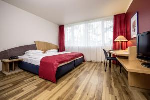 纽伦堡阿维娜会展中心酒店的配有一张床和一张书桌的酒店客房