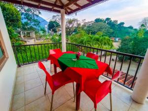 MonaragalaKING TOP Holiday Inn的阳台上配有红色的桌椅,享有风景。