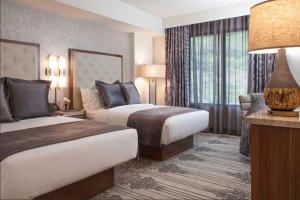 圣地亚哥Legacy Resort Hotel & Spa的酒店客房设有两张床和大窗户。