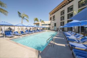圣地亚哥Legacy Resort Hotel & Spa的一个带椅子和蓝伞的游泳池