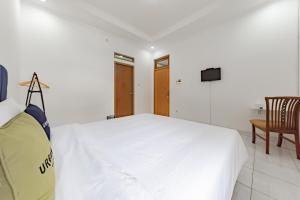 万隆RedDoorz Plus near Universitas Maranatha Bandung 2的一间白色卧室,配有床和电视