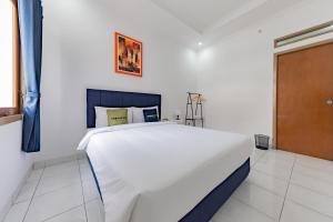 万隆Urbanview Hotel My Honai Setrasari by RedDoorz的一间白色卧室,房间内设有一张大床