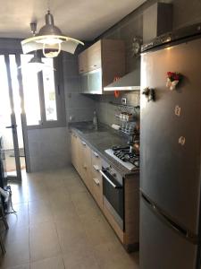 西迪布克纳德尔Luxury Apprt 2 ch ,prestigia des nations的厨房配有不锈钢冰箱和炉灶。