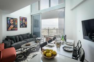 特拉维夫Luxury 3BR Duplex with Sea View in Tel-Aviv Center by Sea N' Rent的客厅配有桌子和沙发