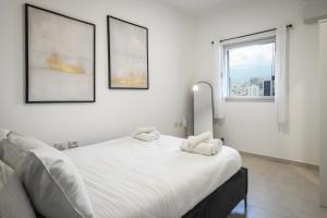 特拉维夫Luxury 3BR Duplex with Sea View in Tel-Aviv Center by Sea N' Rent的卧室配有白色的床和2条毛巾