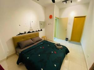峇六拜Cozy 3BR Apartment with Free Netflix的一间卧室配有一张带绿色棉被的床